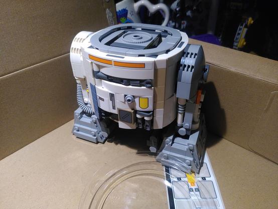 Photo of lego 75416 with bag 5/7 finished. It's the torso and legs of a star wars astromech. Body and right "legs" are white with bit of gray, left leg is gray with bit of white and orange