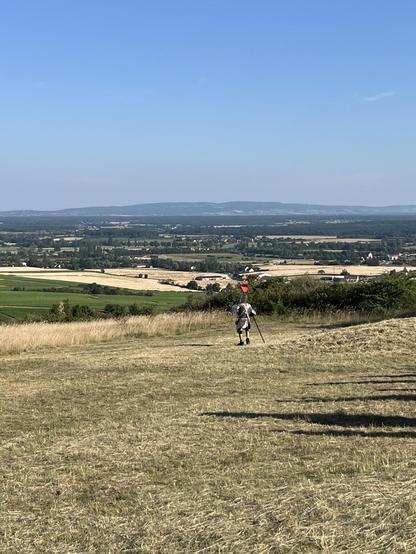 Sud Bourgogne. Un chevalier loufoque et sans cheval  observe les champs à perte de vue, et les collines. Ciel bleu.