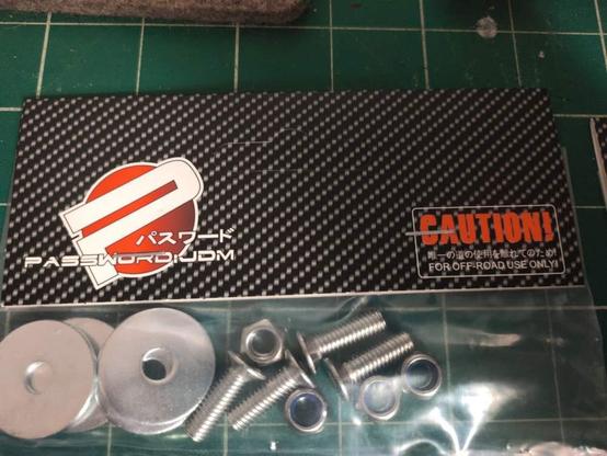 Tagged and bagged product with screws and washers

On the tag is a logo with a P in s circle, which is overlapped with text. The top line of text is some Asian text, and the bottom is "Password: JDM"