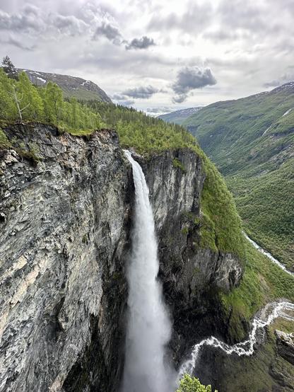 A dramatic mountain scape with a huge waterfall that goes over a cliff down over 250m into the valley below