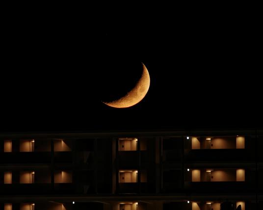 Moon and a hotel. Both are orange hued. The moon because of the humid haze.