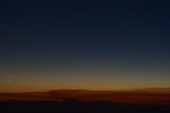 A dozen minutes later, in faint twilight, Venus and Castor and Pollux are closer to the horizon. Many stars are becoming visible, as well as satellite trails in this two-second exposure.