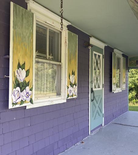 Purple cottage with shutters painted with large soft mauve flowers