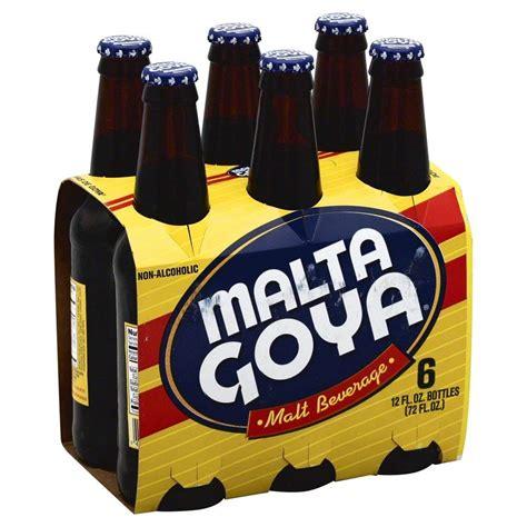 Product image of a six pack of Malta Goya. Paperboard packaged long neck glass bottles, looking like beer, but labeled "nonalcoholic". The name is in a blue oval with red stripes behind it, the rest of the label is yellow