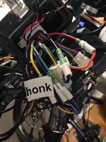 A bunch of cables coming out of the bike frame, one is labled "honk"