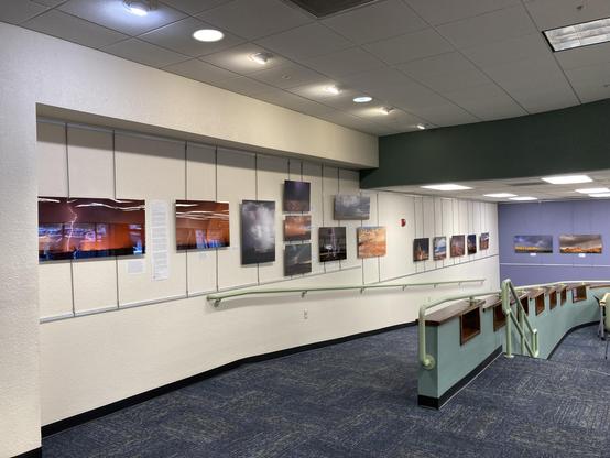 An open indoor space in a library with brightly colored photos on the wall.