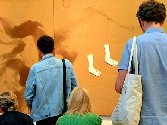 Partial view of a group of visitors contemplating the work "Gran dípctic dels mitjons" (The Great Diptych of Socks) a 1987 mixed-media painted by the Catalan artist Antoni Tàpies, housed at the Fundació Antoni Tàpies in Barcelona. In this diptych, and alongside other elements, a pair of real Socks appear recycled into Artwork.
