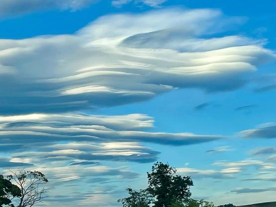 A photo of some lenticular clouds. Like stacks of giant plates in the sky, they look slightly unrealistic.