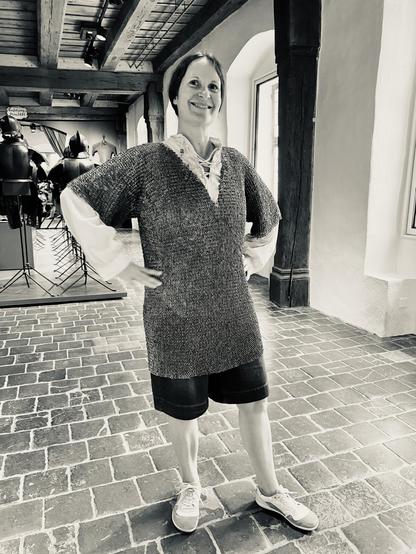 A woman wearing chain mail, grinning