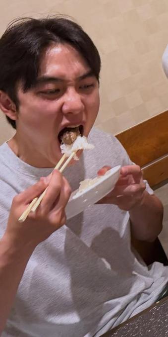 Kpop star Doh Kyungsoo in a behind-the-scenes photo takes a giant bite of rice.