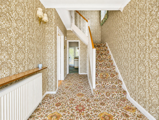 An actual house for sale in England with monstrous patterned carpets, wallpapers and stairs