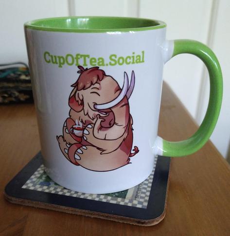 Green cupofteasocial mug on a bedside cabinet