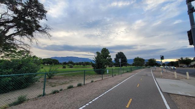 A wide angle shot from the same position, showing the breadth of the grey sky. The trail seems to disappear into infinity after a slight turn. Even the yellow of the trail median stripes pop in this lighting. It doesn't even look like morning. It looks like I better get home quick because it's getting dark fast.