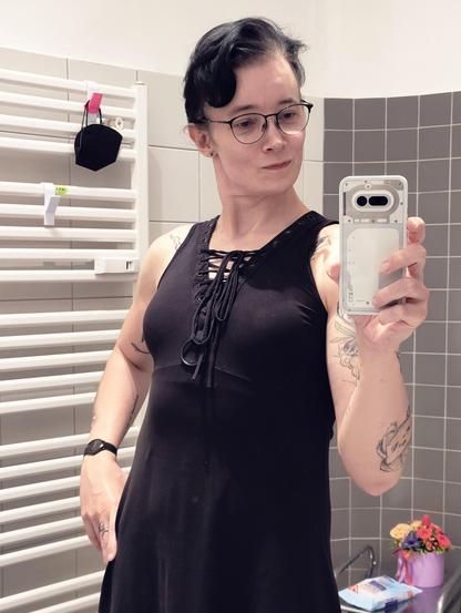 Mirror selfie in a bathroom. Wearing a black dress