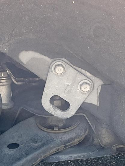 A pareidolic metal bracket. Two bolts are its eyes and an open cutout forms a mouth in perpetual “AHHHHH!”
