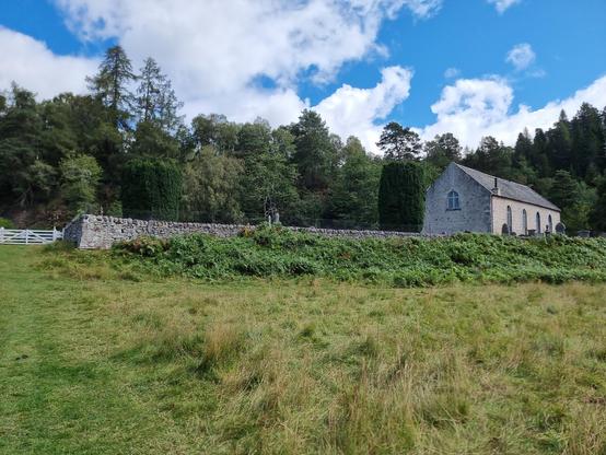 The church at Ardclach, lying in a bend of the River Findhorn. A white-painted gate leads back to the car park and keeps the sheep in their place.