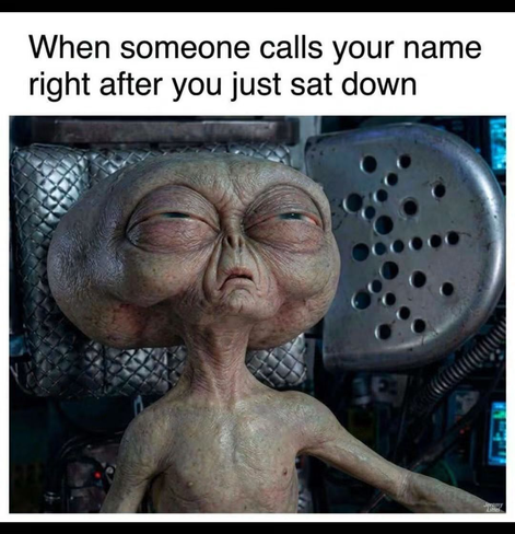 Meme featuring a tired, annoyed-looking alien slumped in a chair. The top text reads: "When someone calls your name right after you just sat down".